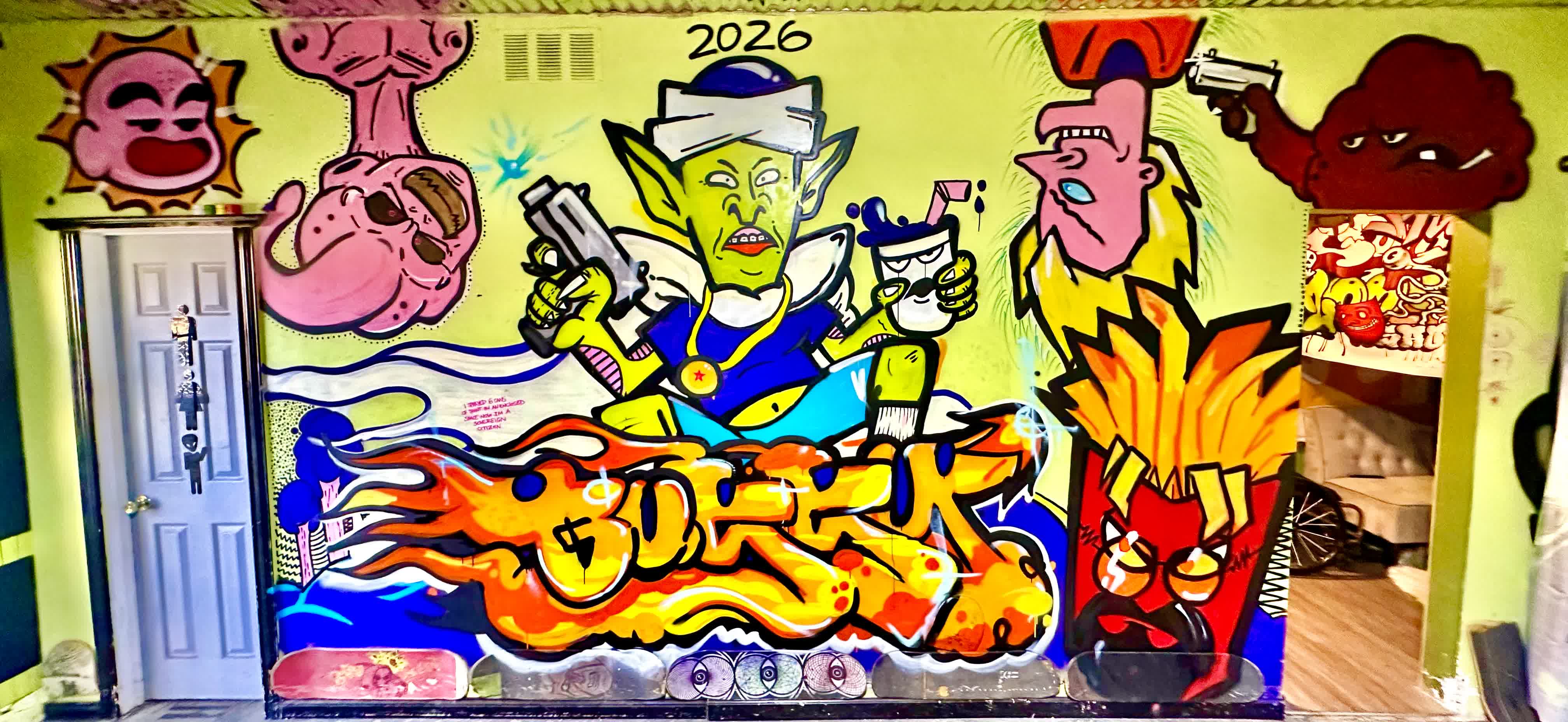 2026 graffiti mural with a green goblin character and orange flame lettering on the shop wall