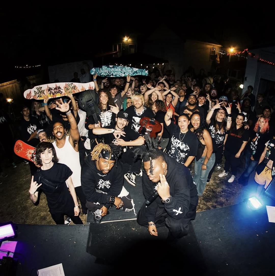 Concert crowd at night holding up painted skateboard decks